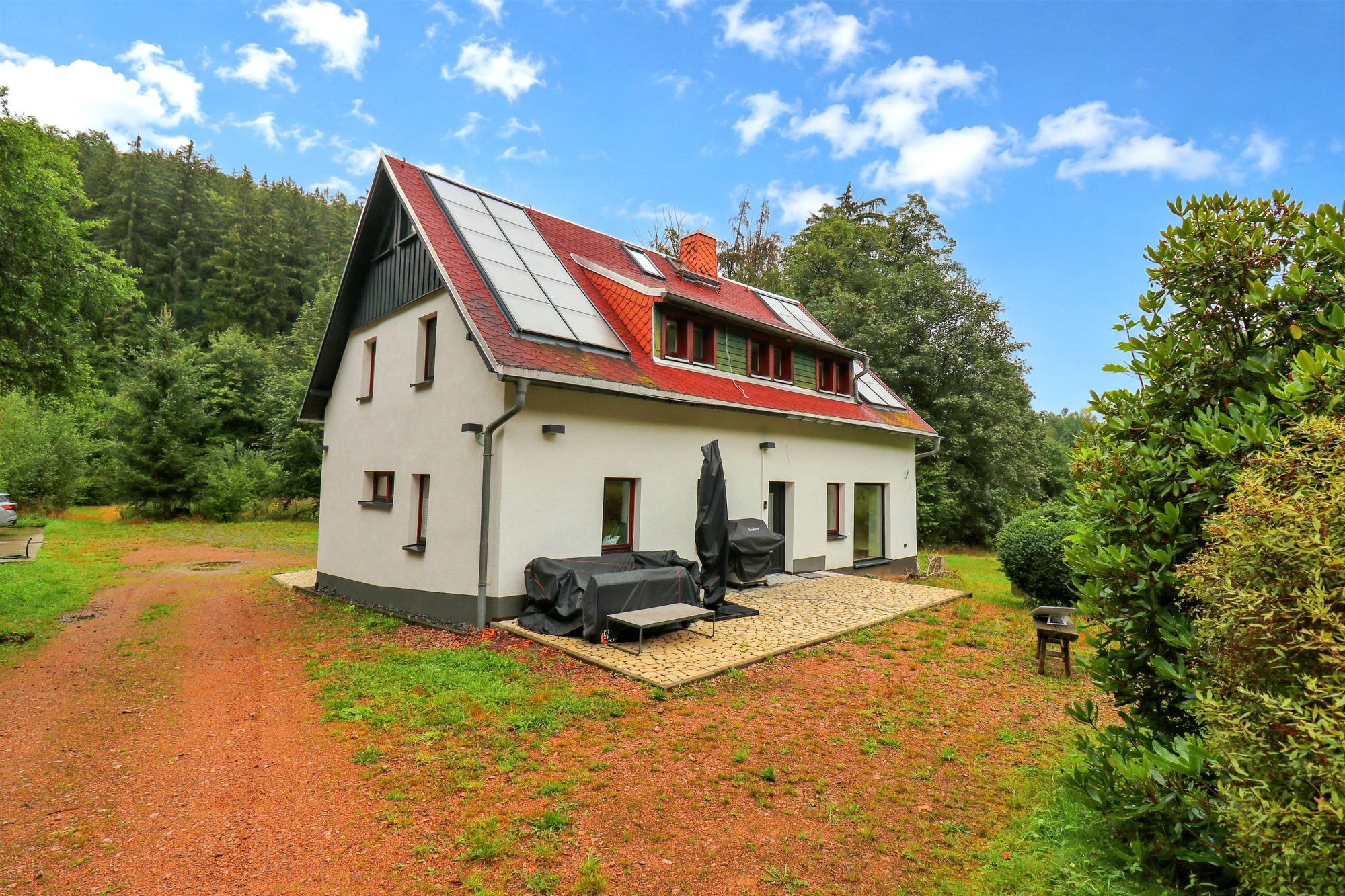 Dunkle Holzfassade und Eckterrasse der Lodge Bärenstein mit Blick ins Tal