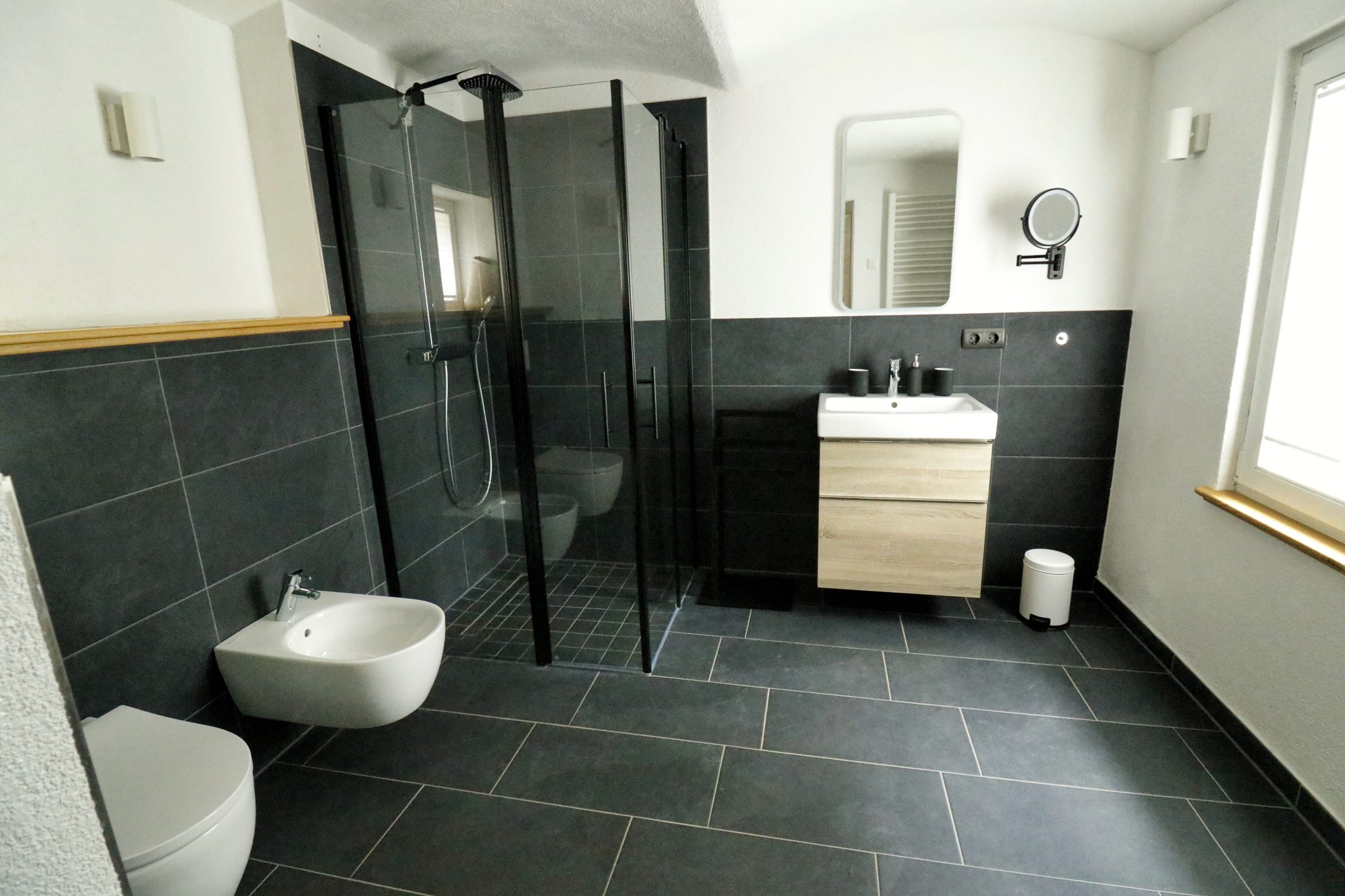 Badezimmer der Lodge mit schwarzer Dusche, Waschbecken und Bidet