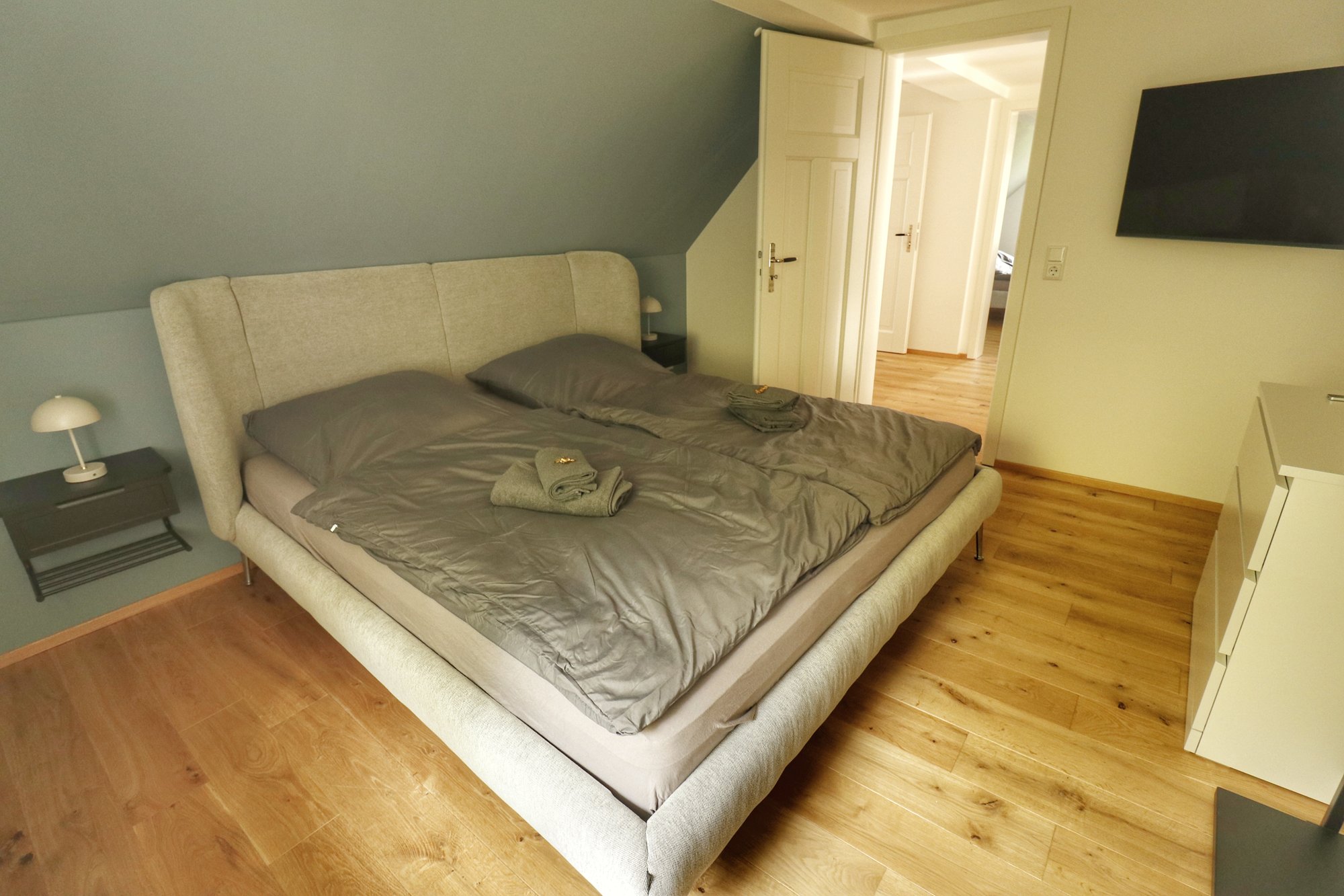 Schlafzimmer der Lodge mit Doppelbett und Blick ins Grüne